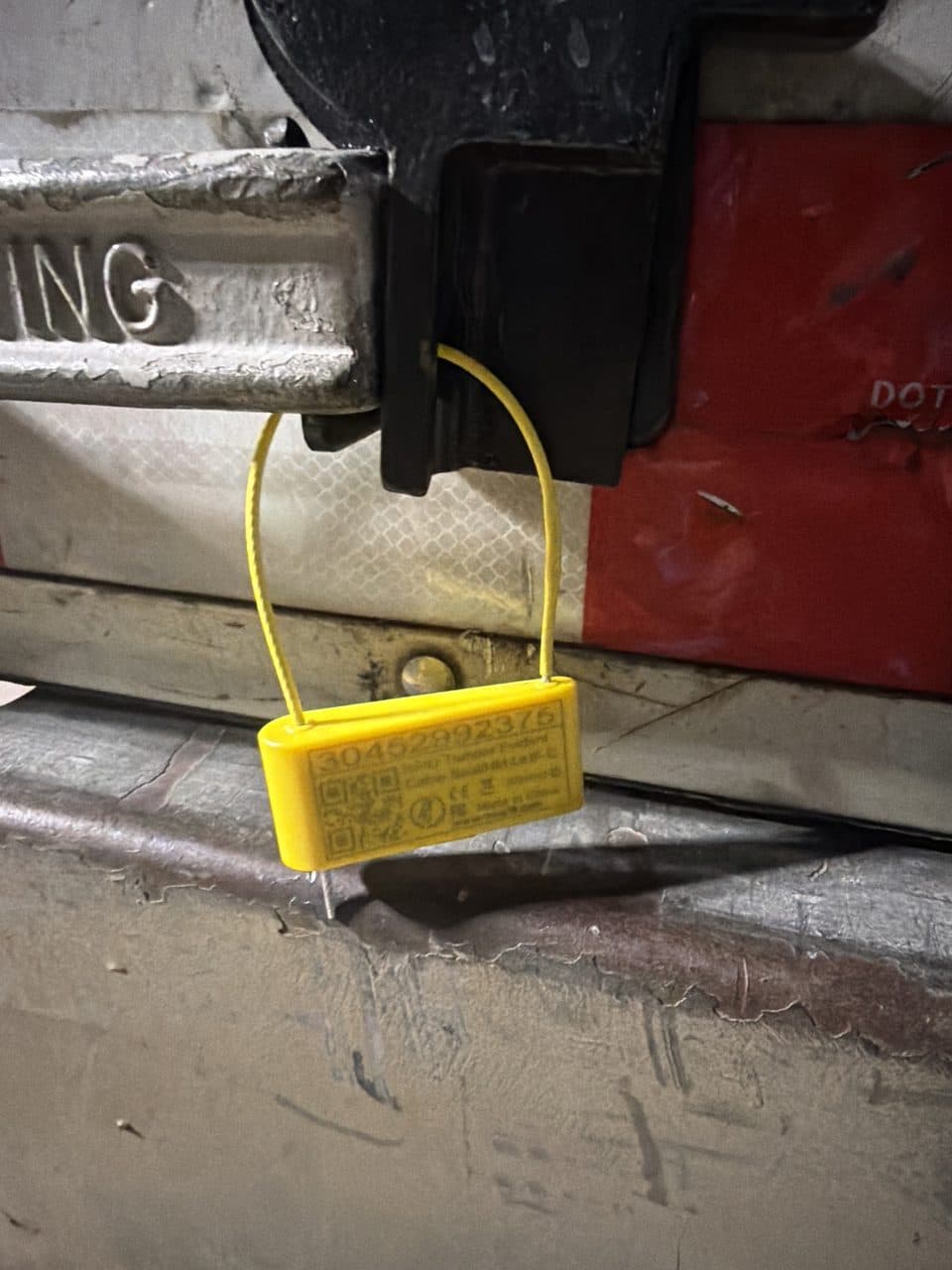 Yellow cable seal locked through the trailer door latch