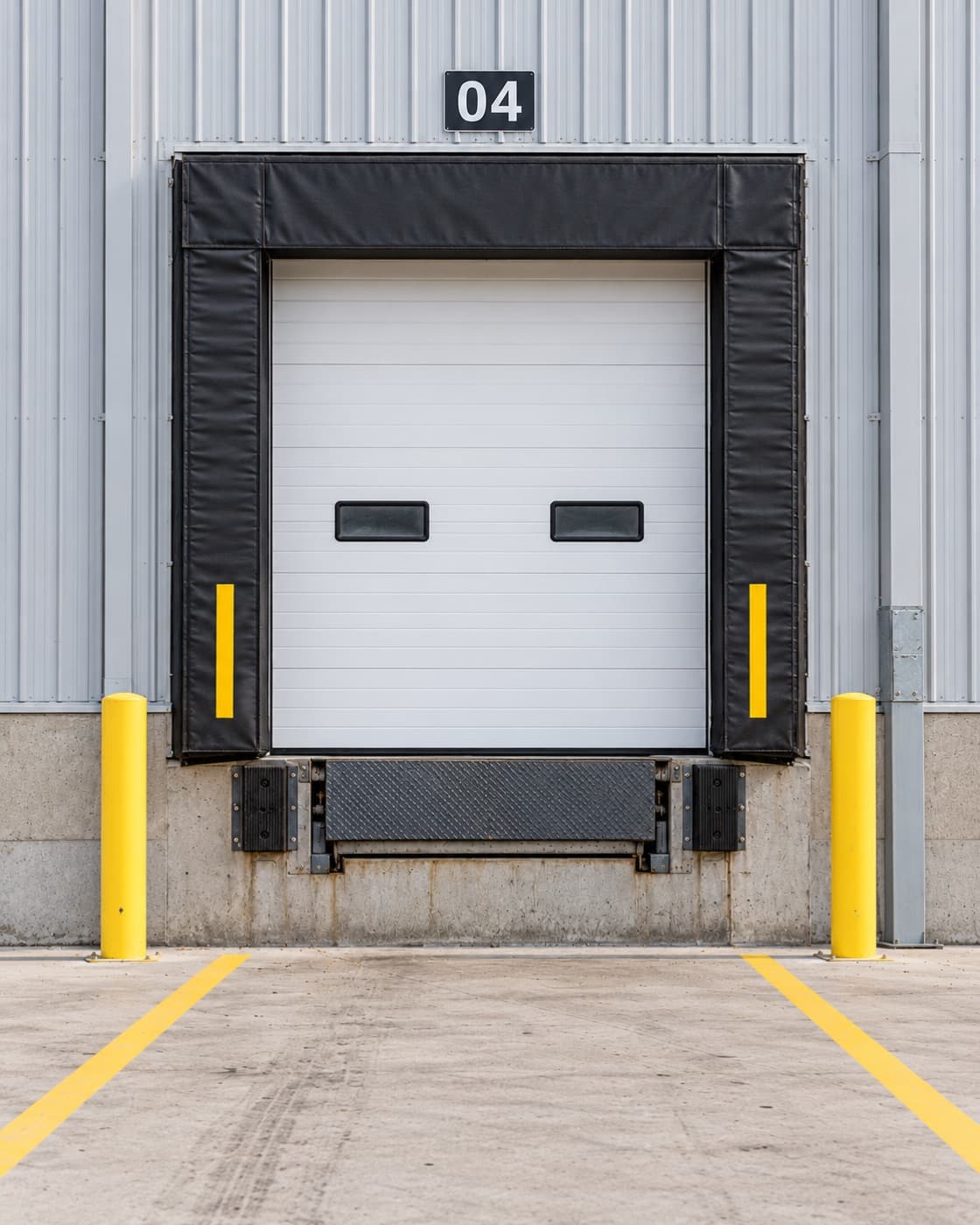 Loading dock door 04 between two yellow bollards